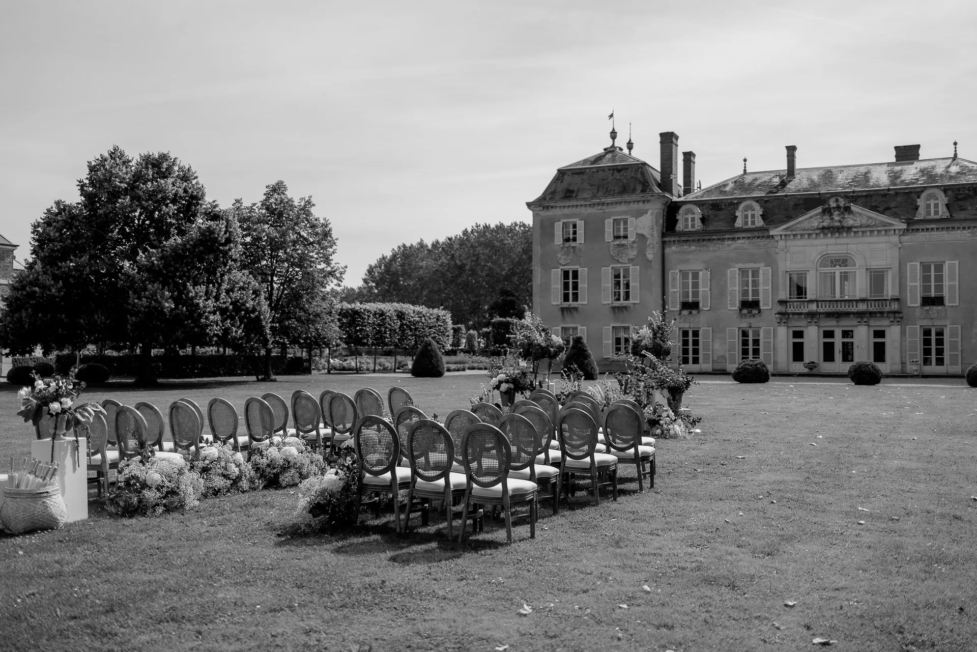 Black and white wedding photography of ceremony setup at Chateau de Varennes with elegant chair arrangement